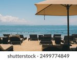 Beach scene at the Holiday Inn in Nusa Dua, Bali, Indonesia, featuring sun beds and umbrellas for relaxation by the sea