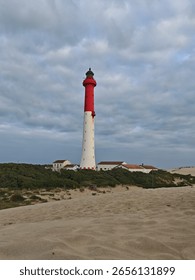 Beach scene with lighthouse light cloudy sky's