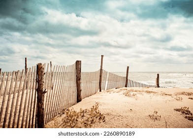 Beach scene on Long Beach Island, New Jersey.  Fence, dunes and moody sky. - Shutterstock ID 2260890189