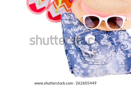 Beach set - Denim blue jeans shorts with white pattern, hat with pink stripe, sunglasses and color beach slippers are isolated on white background. Headphones is in back pocket. Shell.