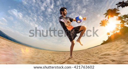 Beach soccer player in action. Sunny beach wide angle