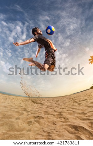 Beach soccer player in action. Sunny beach wide angle