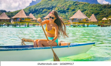 Beach sport tourist woman paddling in outrigger canoe Tahiti activity. Vaa French polynesia polynesian watersport.