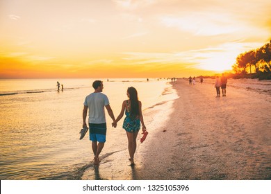 Beach summer beach people lifestyle happy couple enjoying sunset walk on Shelling beach famous tourist destination on the southwest coast of Florida -Gulf of Mexico. Sanibel Island, Florida. - Powered by Shutterstock