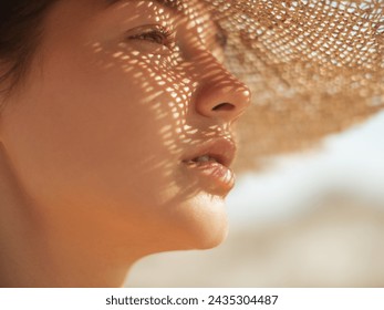 Beach sun hat woman during vacation. Close-up of a girl's face in straw sunhat enjoying the sun looking away. - Powered by Shutterstock