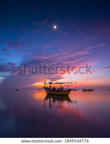 Beach sunrise or sunset over the tropical sea and sky with clouds fishermen get ready