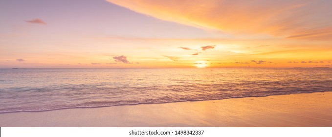 Beach sunset. Beautiful panoramic landscape, colorful golden sunset over calm sea with waves splashing softly on sandy beach. Amazing sunset landscape, summer nature, peaceful nature - Powered by Shutterstock