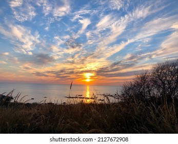 Beach sunset with a blue somewhat cloudy sky and with a beautiful mix of colors captured on the photo.