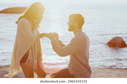 Beach, sunset and couple with proposal for marriage on summer vacation, holiday or travel. Love, happy and young man and woman by ocean for romantic engagement surprise on weekend trip in Australia. - Powered by Shutterstock