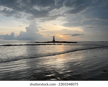 Beach in the sunset and lighthouse.