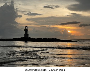 Beach in the sunset and lighthouse.