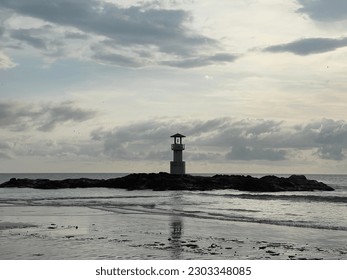 Beach in the sunset and lighthouse.