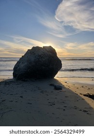 Beach sunset with rock and waves
