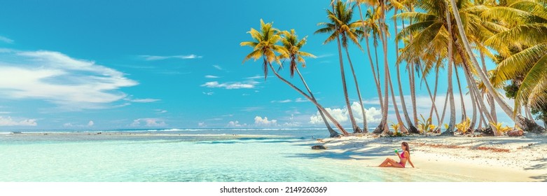 Beach suntan bikini woman sunbathing lying in ocean drinking tropical drink. Travel vacation paradise banner panorama background copy space on blue sky - Shutterstock ID 2149260369