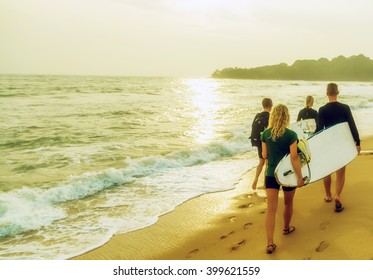 Beach Surfers Running Into The Sea With Surf Boards