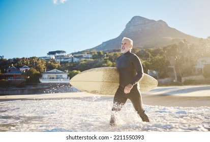 Beach, surfing and senior man with a surfboard walking in the ocean water for training on vacation. Adventure, exercise and elderly surfer in the sea while on a retirement holiday in Bali Indonesia. - Powered by Shutterstock