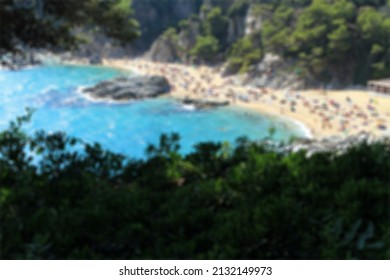 Beach Surrounded By Green Hills And Crowd Of People On Vacation Aerial Shot In Blurred Background