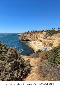 Beach surrounded on one side by rocky cliffs and on the other by the calm waters of the ocean