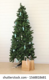 Beach Themed Minimally Decorated Christmas Tree With Shiplap Background.