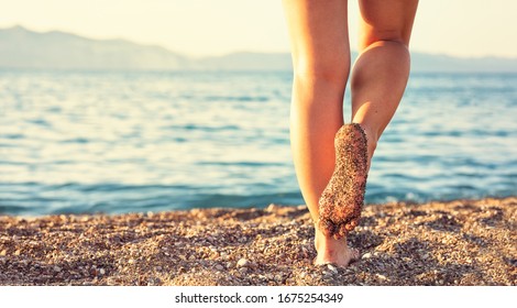 Beach travel concept. Legs on tropical sand beach. Walking female feet. Close up