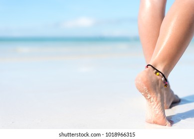 Beach Travel Concept. Sexy Legs On Tropical Sand Beach. Walking Female Feet. Closeup