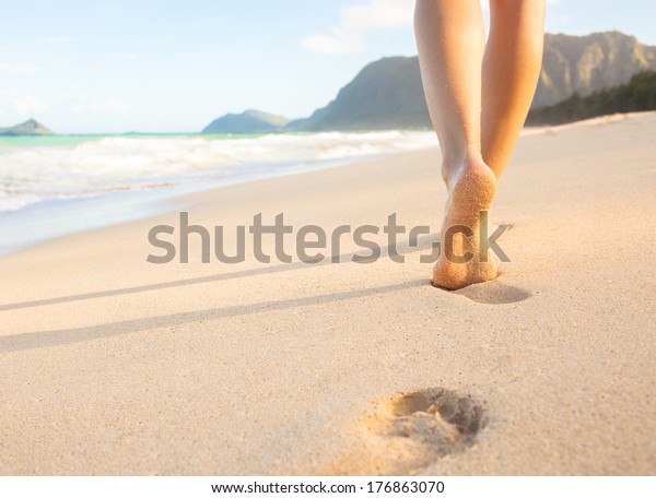 ビーチトラベル 砂浜を歩く女性が 砂に足跡を残す ハワイのビーチの女性の足と金色の砂の接写 の写真素材 今すぐ編集