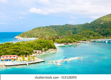 Beach and tropical resort, Labadee island, Haiti. Exotic wild beach with palm and coconut trees against blue sky and azure water