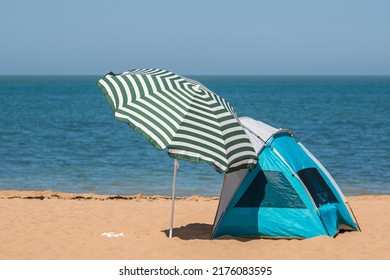 Beach umbrella and sun shelter tent on the beach of Botany Bay in the seaside town of Broadstairs, east Kent, England - Shutterstock ID 2176083595
