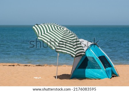 Beach umbrella and sun shelter tent on the beach of Botany Bay in the seaside town of Broadstairs, east Kent, England
