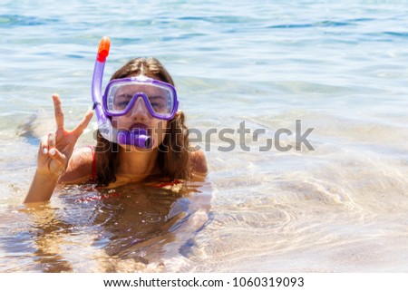 Beach vacation fun woman wearing a mask tube for swimming in ocean water. Close-up portrait of a girl in her travel holidays.