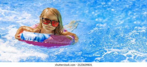  Beach Vacation In Summer By The Sea -  Child In Swimming Pool On Ring Toy. Kids Swim. 