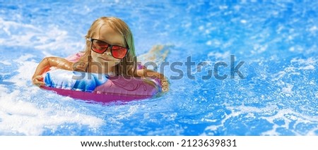  beach vacation in summer by the sea -  Child in swimming pool on ring toy. Kids swim. 