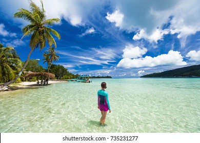 Beach Vacation Tourist Woman Swimming In French Polynesia Island On Cruise Excursion At Huahine Paradise Motu. Tahiti Travel Holiday. Girl Wearing Sun Protection Clothing Rashguard For Solar Skincare.