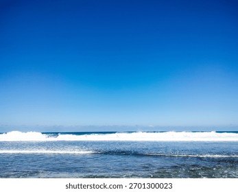 beach view, with a composition of blue sky, sea water, waves and sandy coast, providing a gradient of color