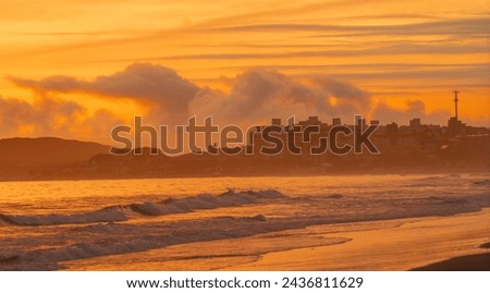 Beach with a view of the sunset and the city at the end of the day