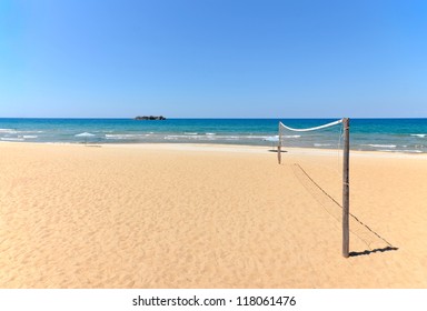 Beach Volleyball Net On Sandy Beach With Sea And Blue Sky In The Background