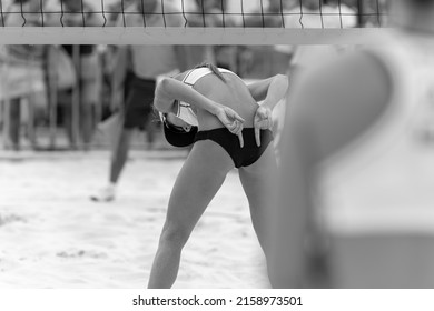 A Beach Volleyball Player Is Sending Signals To Her Team Mate In Black And White Image Format