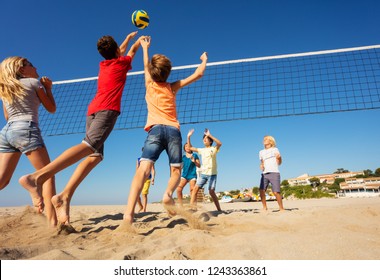 Beach Volleyball Players Jumping To Spike The Ball