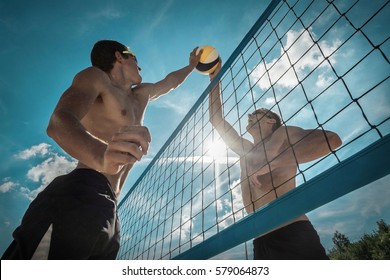 Beach Volleyball players in sunglasses under sunlight. Dynamic sport action outdoor.