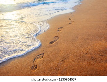 Beach, Wave And Footprints At Sunset Time