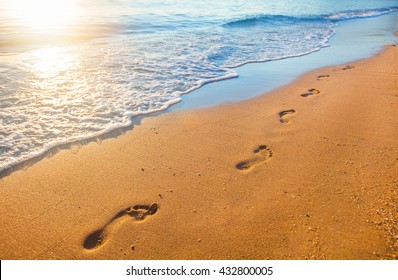 Beach, Wave And Footprints At Sunset Time