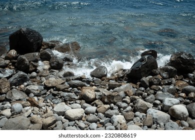 Beach with waves and rocks.
