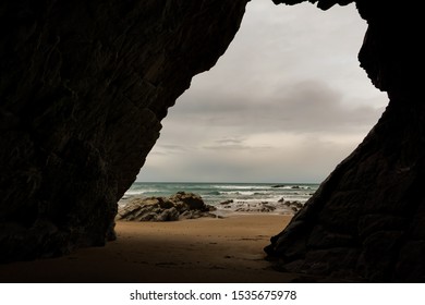 Beach with waves seen from inside a cave