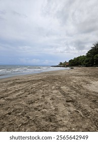 Beach with waves under cloudy sky