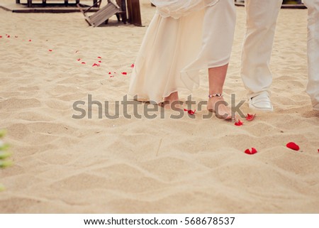 Beach wedding bride and her father are walking