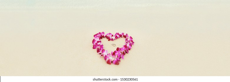 Beach Wedding Proposal Rings In Heart Shap Lei Flowers Necklace On White Sand Hawaii Honeymoon. Two Diamond Rings Lying On Sand For Marriage Proposal In Tropical Vacation Destination Panoramic Banner.