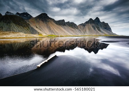 Beach with wet black sand. Picturesque and gorgeous scene. Popular tourist attraction. Location place Stokksnes cape, Vestrahorn (Batman Mountain), Iceland, Europe. Artistic picture. Beauty world.