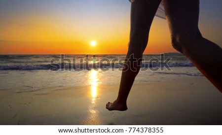 Beach woman running in water at sunset enjoying freedom during summer holidays vacation travel. Beautiful happy free mixed race Caucasian female girl