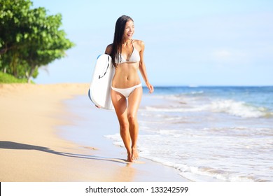 Beach woman swimming fun with body surfboard. Happy beautiful bikini model running on beach on summer vacation holidays. Mixed race Asian / Caucasian woman on Kaanapali beach, Maui, Hawaii.
