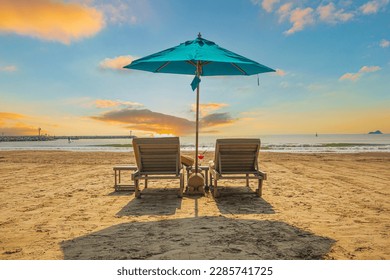 Beaches and sun tables in Thailand,Row of empty sun loungers and orange parasols on the tropical beach at sunset. Vacation in the all inclusive hotel on the Caribbean sea  - Powered by Shutterstock